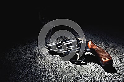 Gun with smoke on the floor, high contrast image Stock Photo