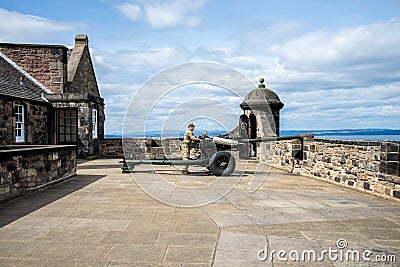 A gunner is servicing One O`Clock gun in Edinburgh Castle Editorial Stock Photo