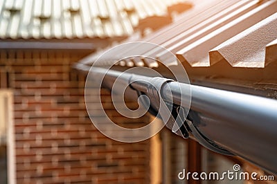 . Gutter system for a metal roof. Holder gutter drainage system on the roof Stock Photo