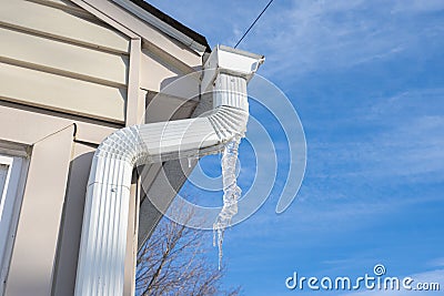 Gutters have frozen and icicles hang from the ice dams Stock Photo