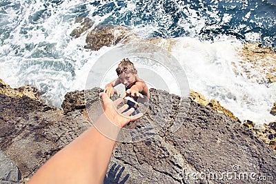 Guy asking for help to someone to climb a cliff Stock Photo