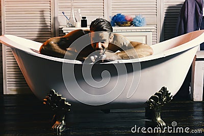 Man with beard and flirting look taking bath Stock Photo