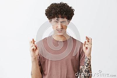 Guy believes in power of mind. Intense serious-looking determined and ambitious guy with curly hairstyle and tattoos Stock Photo