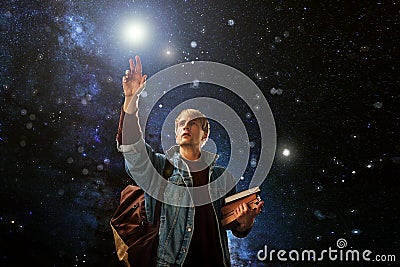 Guy with the books reaches for the stars, the concept of imagination. Stock Photo