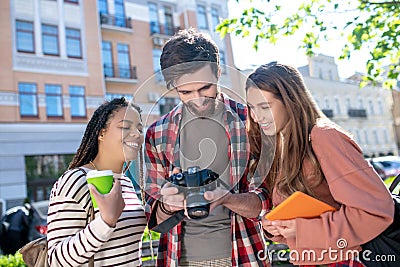 Guy with a camera showing girls pictures Stock Photo