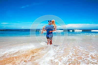 The guy is carrying his girlfriend to the ocean Stock Photo