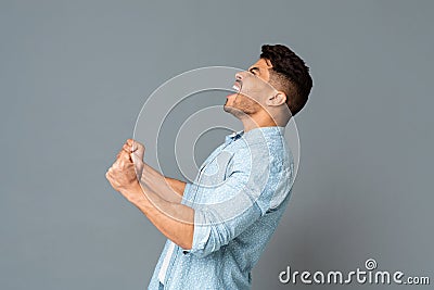 Guy With Clenched Fists Screaming Or Roaring Loudly, Side View Stock Photo