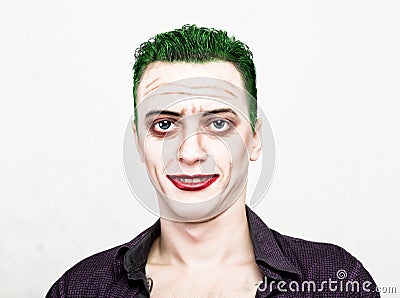 Guy with crazy joker face, green hair and idiotic smike. carnaval costume Stock Photo