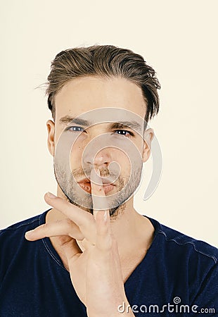 Guy in dark blue tshirt shows silence sign Stock Photo