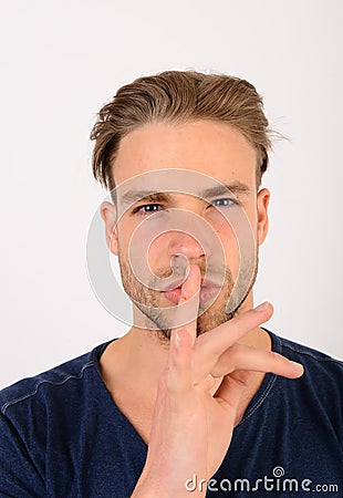 Guy in dark blue tshirt shows silence sign Stock Photo