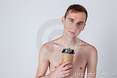 Naked handsome guy drink from coffee or tea cup. Morning refreshment and drink Stock Photo