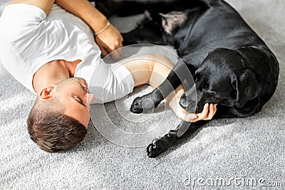 Guy freelancer with his dog labrador playing at home Stock Photo