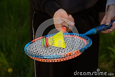 A guy and a girl are holding colorful badminton rackets. On the rackets there is a bright multi-colored flan Stock Photo