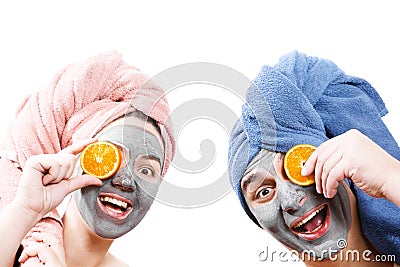 A guy with a girl looks at the camera and hold orange slices near the face , mask for skin man and woman, guy with a girl make a Stock Photo