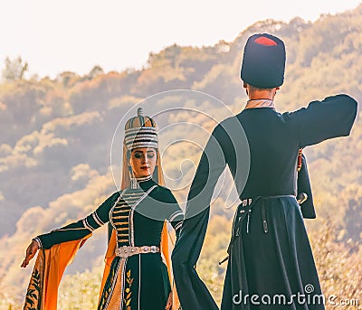 A guy with a girl in traditional Circassian clothes dancing at the festival of Adyghe cheese in the foothills of the Caucasus Editorial Stock Photo