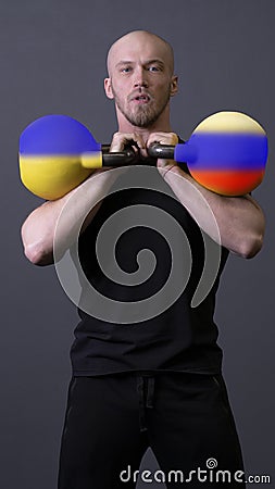 The guy with the kettlebells is standing russia ukraine ukrainian national, for government battle for concept and Stock Photo