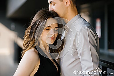 The guy kisses the girl on the head with his eyes closed. The concept of love, awe, love. Valentine`s Day Stock Photo