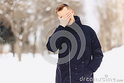 The guy with light short hair in a winter jacket made a facepalm Stock Photo