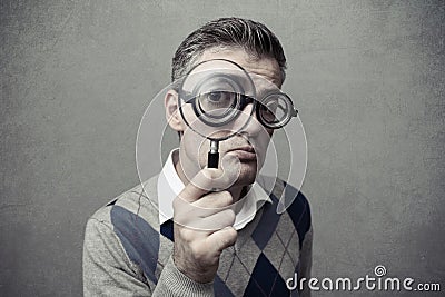 Guy looking through a magnifying glass Stock Photo