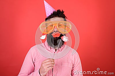 Guy in party hat celebrate, posing with photo props. Hipster in giant sunglasses celebrating. Emotional diversity Stock Photo