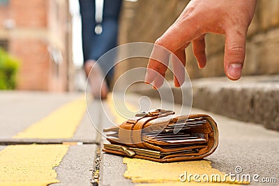 Guy picking up a lost a lost purse/wallet Stock Photo