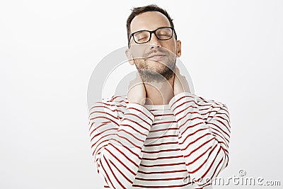 Guy recalls nice feeling of lovers hands. Sensual romantic european gay model in glasses, closing eyes and tilting head Stock Photo