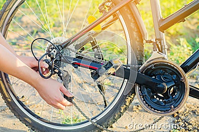 The guy repairs the bicycle. chain repair. cyclist. unratitude on the road, travel, close-up. Stock Photo