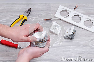 The guy sets the sockets in the room. Repair in the house. Stock Photo