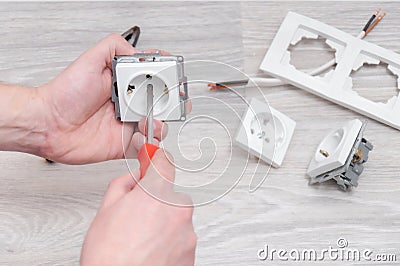 The guy sets the sockets in the room. Repair in the house. Stock Photo