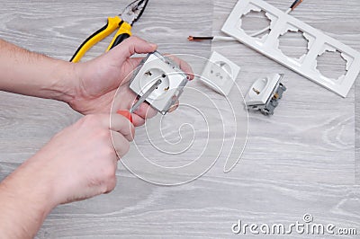 The guy sets the sockets in the room. Repair in the house. Stock Photo