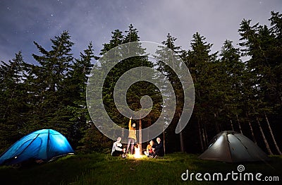 Guy is showing his friends the starry sky over tent city. Outdoor recreation Stock Photo