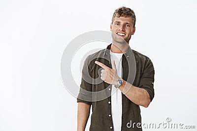 Guy showing us cool place inviting join. Friendly-looking sociable and carefree handsome masculine blond man with watch Stock Photo
