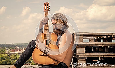 guy sitting outdoor. mature hipster musician with beard. brutal caucasian guy playing guitar. country music. bearded man Stock Photo