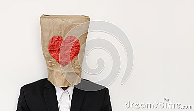 A guy in suit wearing brown paper bag with heath shape Stock Photo