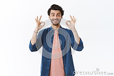 Guy thinks your choice perfect, giving approval. Impressed good-looking bearded man showing okay, ok or good gesture Stock Photo