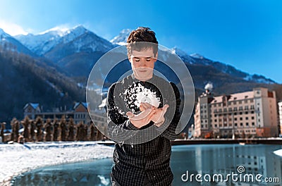 The guy throws snow against the mountains, around winter Stock Photo