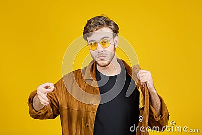 guy with yellow sunglasses posing on a yellow background Stock Photo