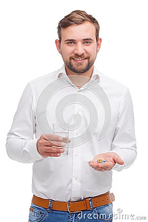 A guy with a smile holds a glass of water and tablets in the palm of a hand on a white isolated background Stock Photo
