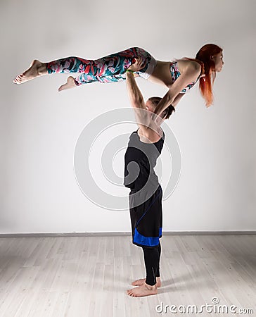 Guy and young woman doing strength exercises in yoga assanes. Acroyoga concept Stock Photo