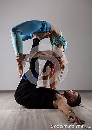 Guy and young woman doing strength exercises in yoga assanes. Acroyoga concept Stock Photo