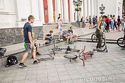 Guys cycling in the town square. Without a helmet Editorial Stock Photo