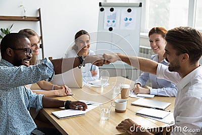 Guys fist bumping congratulating each other with success at work Stock Photo