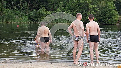 Guys relax on the beach standing on the shore Stock Photo