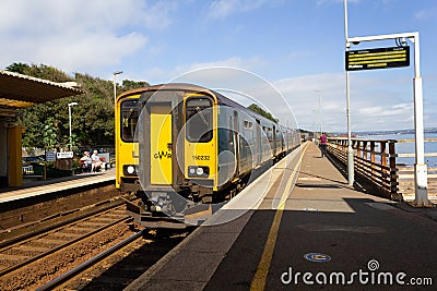 A GWR train arrives at Dawlish railway station in Devon Editorial Stock Photo