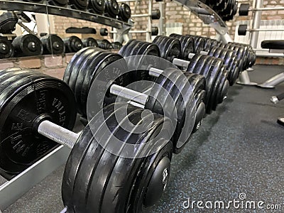 Gym for bodybuilding. Heavy dumbbells and exercise equipment. Barbells and equipment for athletes Editorial Stock Photo