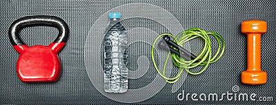 Gym concept. dumbbell, skipping rope,training weight and bottle of water on step equipment background.Healthy lifeslile Stock Photo