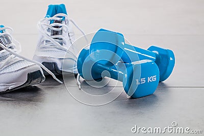 Gym concept with running sneakers and weights for wellness lifestyle Stock Photo