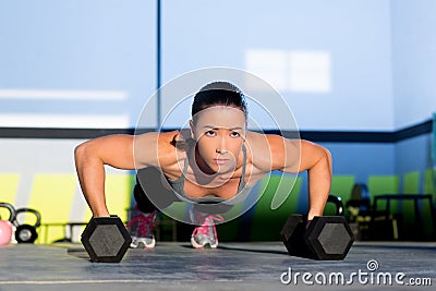 Gym woman push-up strength pushup with dumbbell Stock Photo