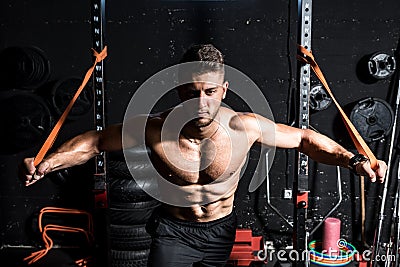 Young strong focused fit muscular man chest stretching workout in improvised gym with rubber for strength and good looking of musc Stock Photo