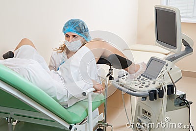 Gynaecologist examining a patient sitting on gynecological chair Stock Photo